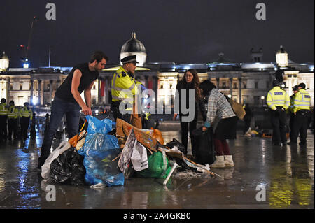 Protesters gather their belongings as police work to remove the last of the Extinction Rebellion demonstration in Trafalgar Square, central London. Stock Photo