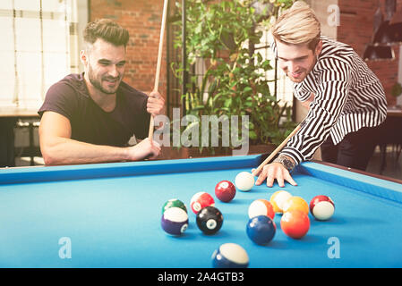 Employees playing in billiards at office. Break from work in the relaxation room Stock Photo