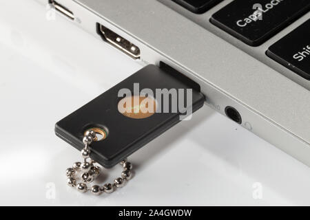 A Yubikey 5 hardware security key plugged into a laptop computer Stock Photo