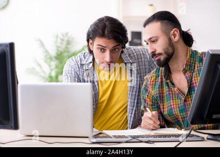 The two it specialists working in the office Stock Photo