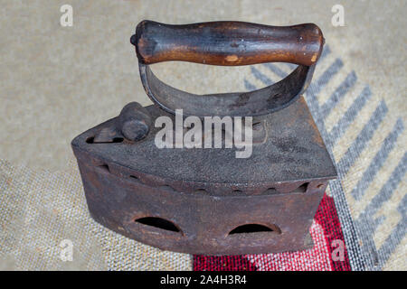 Old coal iron ironing on white fabric background Stock Photo
