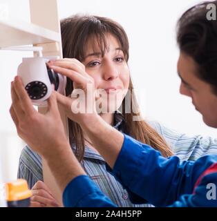 The client getting securty camera installed at home by contractor Stock Photo