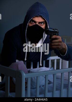 Criminal stealing baby in human child traficking concept Stock Photo