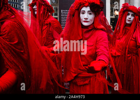 A member of the environmentalist performs art troupe the Red Rebel Brigade during the demonstration.Today marked the start of the second consecutive week of protest actions by XR members gathered in London, more than 1,400 of whom have been arrested in the city for their avowedly non-violent disruptiveness since last Monday. Arrests are viewed as a key tactic by the group, designed to maximise publicity and disruption and so intensify pressure on political leaders to take further and faster action on climate change and biodiversity loss. Extinction Rebellion's blockade of Bank junction began e Stock Photo