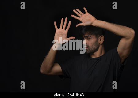 man with seasonal disorder blocking light with hands Stock Photo