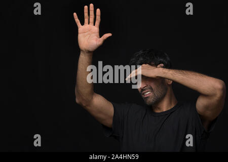 man with seasonal disorder blocking light with hands Stock Photo