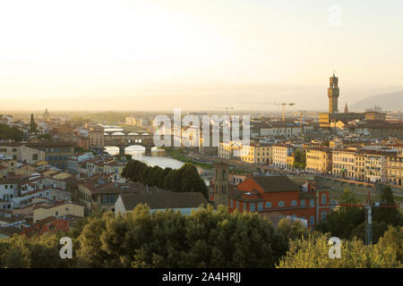 Florence city during golden sunset. Panoramic view of the river Arno with Ponte Vecchio bridge and Palazzo Vecchio palace, Florence, Italy. Stock Photo