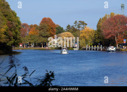 14 October 2019, Brandenburg, Schwielowsee/Ot Caputh: A motorboat drives on the Caputher Gemünde before the scenery of autumnally colored trees. The Caputher Gemünde is a narrow place between Schwielowsee and Templiner See. Photo: Soeren Stache/dpa-Zentralbild/ZB Stock Photo