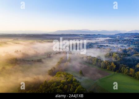 Cultural landscape, forest and meadows with Loisach in the morning fog, in the background foothills of the Alps, near Gelting near Geretsried Stock Photo