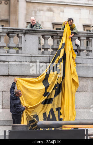 Extinction Rebellion encampment at Trafalgar Square, London, UK. Protest camp. Activists fitting a large banner Stock Photo