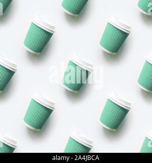 Many green cup of coffee takeaway paper cups as seamless pattern on white background. Flat lay style. Top view. Stock Photo