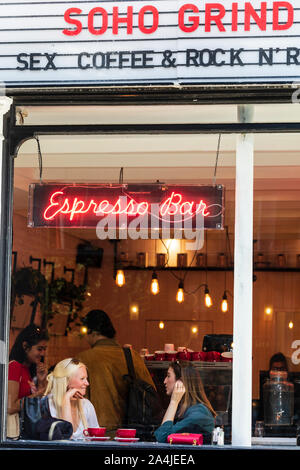 Two young women having coffee inside the Soho Grind espresso bar in Soho, Central London, England, UK. Stock Photo