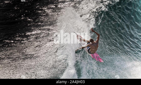 Surfer performing cutback maneuver on the lip of the blue wave at Padang Padang , Bali, Indonesia Stock Photo