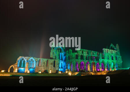 A spectacular light display illuminates the historic Whitby Abbey on October 27, 2015 in Whitby, England. The famous Benedictine abbey will be illuminated over four nights to coincide with Halloween and the popular Whitby Goth Weekend. During this time visitors to the historic English Heritage location will see the abbey bathed in spectacular light as well as experiencing the site after dark The Abbey was part of the inspiration for Bram Stoker's novel, Dracula, and sits on East Cliff in the town in a commanding position overlooking the North Sea. Stock Photo