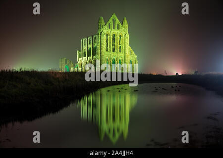 A spectacular light display illuminates the historic Whitby Abbey on October 27, 2015 in Whitby, England. The famous Benedictine abbey will be illuminated over four nights to coincide with Halloween and the popular Whitby Goth Weekend. During this time visitors to the historic English Heritage location will see the abbey bathed in spectacular light as well as experiencing the site after dark The Abbey was part of the inspiration for Bram Stoker's novel, Dracula, and sits on East Cliff in the town in a commanding position overlooking the North Sea. Stock Photo