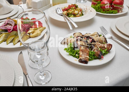 Sliced fried eggplant rolls as a snack on a served table in a restaurant. Stock Photo