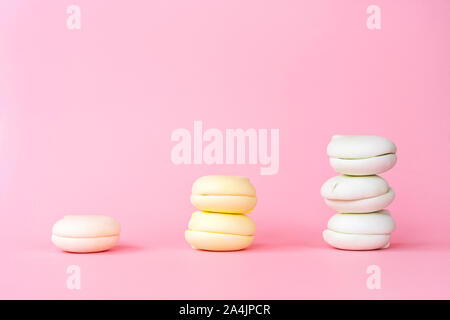 Peach, yellow and green color marshmallows on a pastel pink background Stock Photo