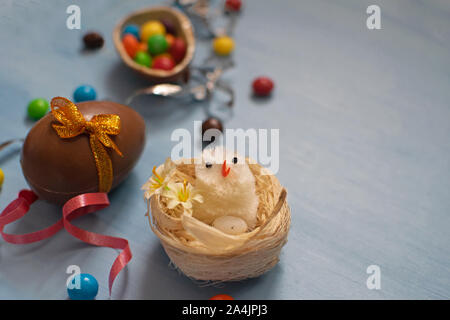 Chocolate Easter eggs and sweets on blue background Stock Photo