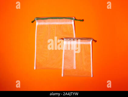 Set of reusable eco bags different sizes on a trendy orange background. An alternative to plastic bags. Zero waste concept, plastic-free, eco-friendly shopping Stock Photo