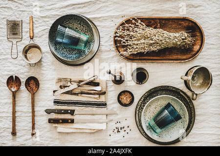 Various kitchen utensils and tablewear over linen tablecloth Stock Photo