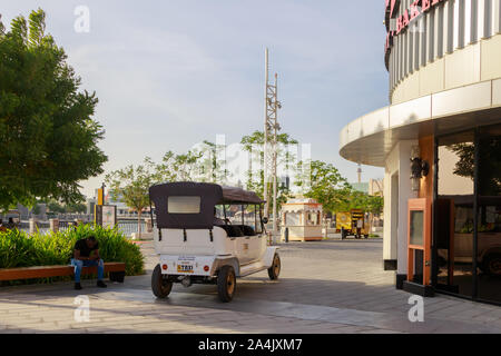 DUBAI, UAE, JANUARY 09, 2019: White electric taxi stands and waits for tourists on the area of Dubai Parks Stock Photo