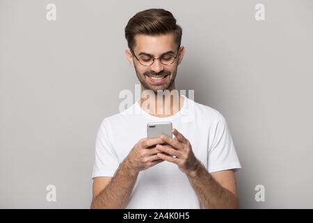 Smiling caucasian man in glasses using modern smartphone Stock Photo