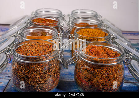 Fragrant spices in a glass jar with a lid and a metal lock on a wooden table Stock Photo