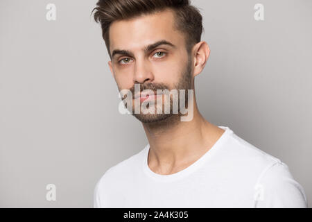 Close up of serious caucasian man posing on grey background Stock Photo
