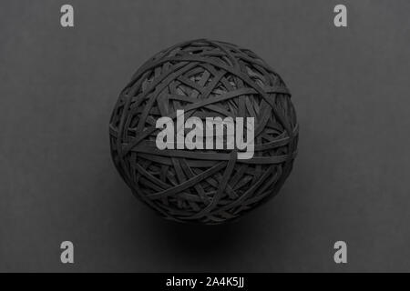 Black rubber band ball isolated on a grey background. 14.10.2019 Please credit: Phillip Roberts Stock Photo