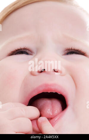 Close-up of small teething girl crying. Milk tooth. Baby tooth. Stock Photo