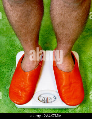 Hairy legs - orange slippers Stock Photo