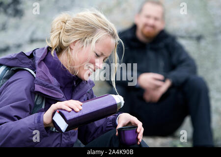 Portrait Of Woman Pouring Coffee And Man Sitting At Background, Outdoors Stock Photo