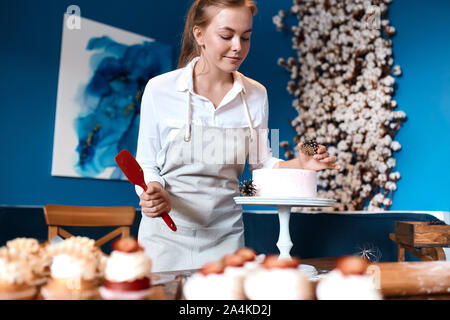 creative cook decorating dessert with pinecorns, close up photo.girl taking parts in cooking contest Stock Photo