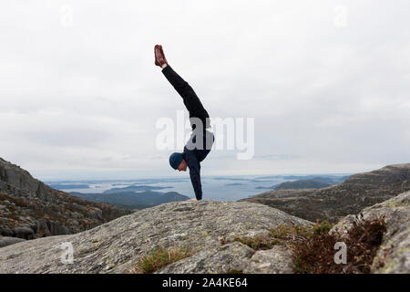 Climber Performing A Handstand On The Top Of Mountain Stock Photo