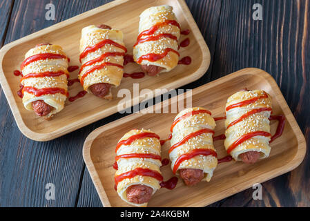 Sausage rolls on the wooden tray: top view