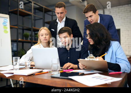 Group of successful clever business people analyzing and discussing problems at the meeting in the modern office room. close up photo. Stock Photo
