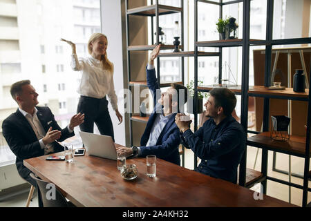 cheerful young office workers celebrating their successful contract in the office with modern interior. close up photo Stock Photo