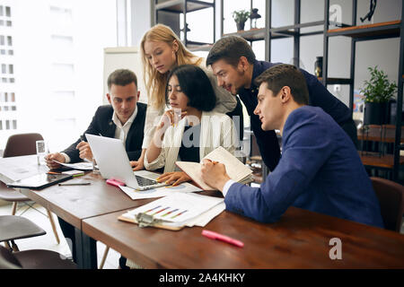 young brunette leader and her colleagues surfing , browsing the internet,close up side view photo Stock Photo