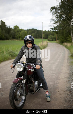 Young Man Sitting On A Motorcycle Wearing Helmet Stock Photo
