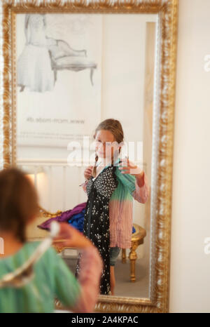 Girl dressing up and looking in mirror Stock Photo