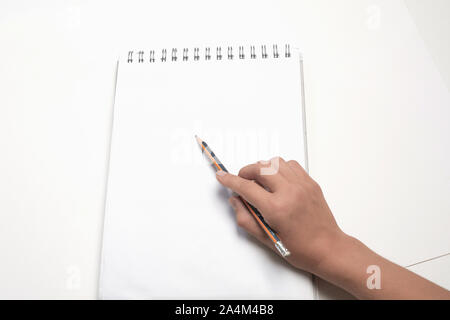 Hand with a pencil on a white background. Women hand holding a pencil on blank sheet of paper Stock Photo