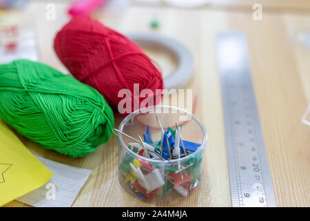 a materials for needlework or sewing, multi-colored threads, pins, needles, ruler, adhesive tape Stock Photo