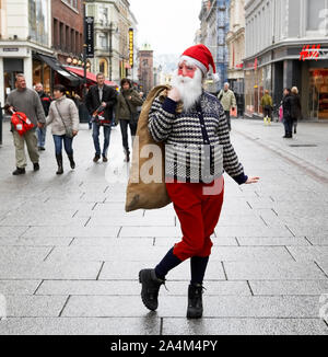 Urban female Santa Claus. Walking in street. With sack. Stock Photo