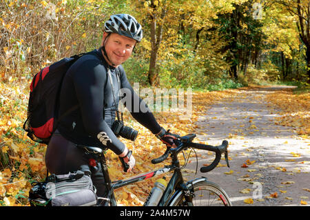 a man with a Bicycle in black clothes, a cyclist in the autumn forest, Rominten Forest, Kaliningrad region, Russia, October 13, 2018 Stock Photo