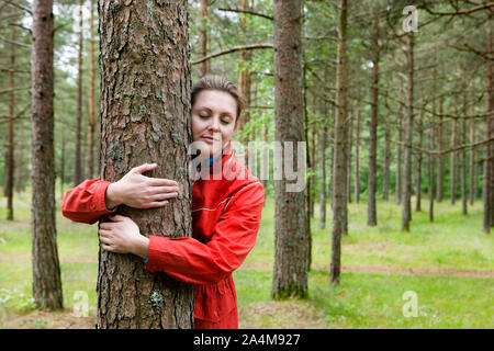 Woman hugging a tree - protecting - eyes shut - tree hugger/tree huggers Stock Photo