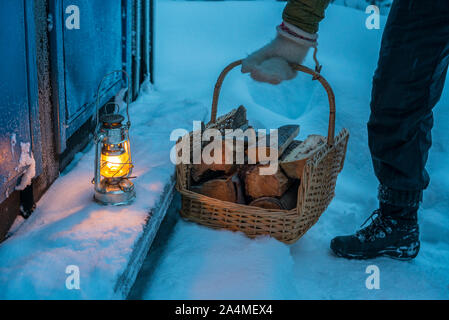 Man with firewood in basket Stock Photo
