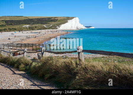 Path along the seashore and beach at Cuckmere Haven on the South Coast, East Sussex, UK, with the Seven Sisters chalk cliffs in the background Stock Photo