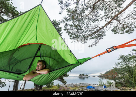Man resting in hammock at lakeshore Stock Photo