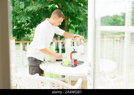 Man preparing coffee on balcony Stock Photo