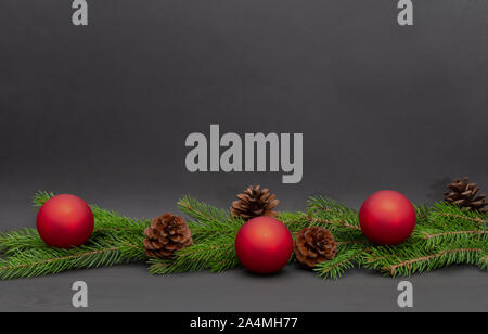 Fir branches, red balls and bumps on dark background. Christmas concept. Free copy space. Stock Photo
